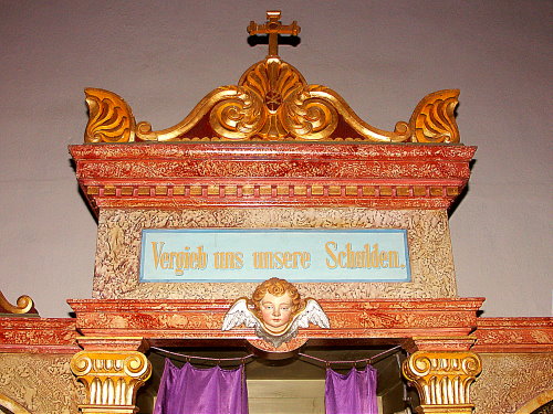 Odpust nam nase dluhy - napis na zpovednici v kostele ve Skorosicich (Gurschdorf)